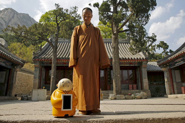 北京西北部龙泉寺，一位僧人和机器人“贤二”，来拜访寺庙的人可以通过机器人的触摸屏获取建议。 